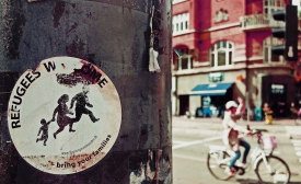 Photo reprinted courtesy of Raven Hawks via Flickr Refugees Welcome, by Raven Hawks