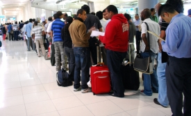 Photo reprinted courtesy Harsha K R, via Flickr https://flic.kr/p/7C1z3b Travelers to Bangkok wait on line for visas