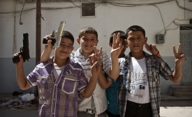 Photo reprinted courtesy Christiaan Triebert, via Flickr https://flic.kr/p/d81gs1 A group of young Syrian boys with toy guns mug for the camera.